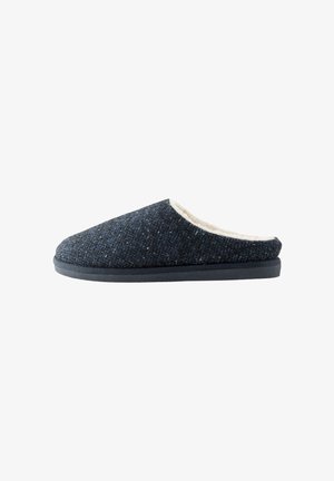 Dunkelgrauer strukturierter Slipper zum Hineinschlüpfen mit weißem Fleecefutter und flacher schwarzer Sohle, von der Seite auf weißem Hintergrund gezeigt.