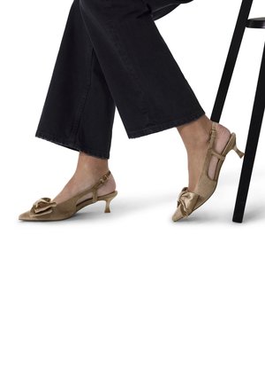 Beige slingback heels made of satin, featuring a bow detail on the toe, pointed shape, and a kitten heel design.