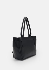 Svart läder tote-väska med dubbla platta handtag, texturerad banddetalj, öppen topp och rektangulär form, med en slät yta och ingen synlig hårdvara.