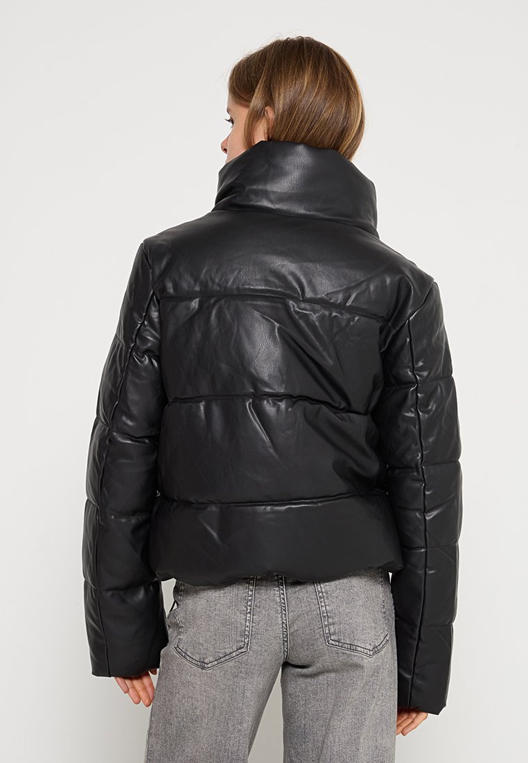 Giubbotto imbottito nero con colletto alto, realizzato in materiale lucido simile alla pelle. Presenta un design trapuntato con pannelli orizzontali e un taglio corto.