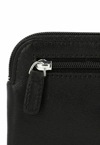 Portafoglio in pelle nera con superficie texturizzata, dotato di una cerniera e un cursore argentati, con dettagli cuciti lungo i bordi.