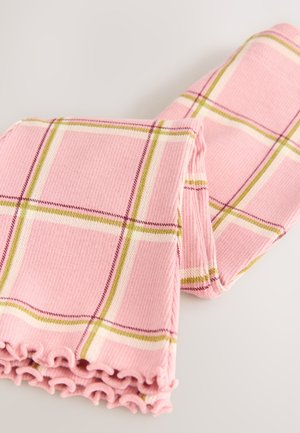 Roza karo odeja z rebrasto teksturo, ki jo krasijo zelene in bele črte. Robovi so zaključeni z naborkom, kar doda detajl dizajnu.