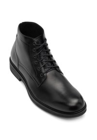 Botín negro de cuero hasta el tobillo con una superficie lisa, punta redonda y seis ojales para cordones. Destaca por su diseño minimalista y su suela resistente.