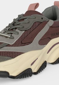 Chunky αθλητικό παπούτσι με γκρι και μωβ δίχτυ επάνω μέρος, ανοιχτό μπεζ χοντρή σόλα, γκρι κορδόνια και μωβ ταινία έλξης στον αστράγαλο.
