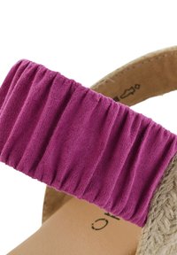 Růžový semišový pásek s nařasenou texturou připevněný k béžové stélce, s přírodní vlákninovou podrážkou. Minimalistický design, bez dalších akcentů.