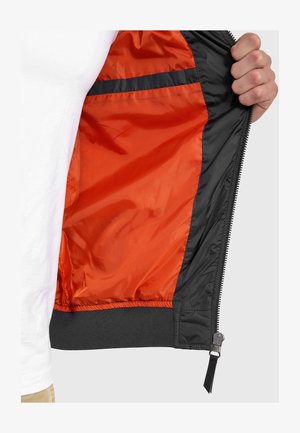 Schwarze Bomberjacke mit orangefarbenem Innenfutter, mit Reißverschluss vorne, gerippten Bündchen und Saum, aus glattem, leichtem Material.