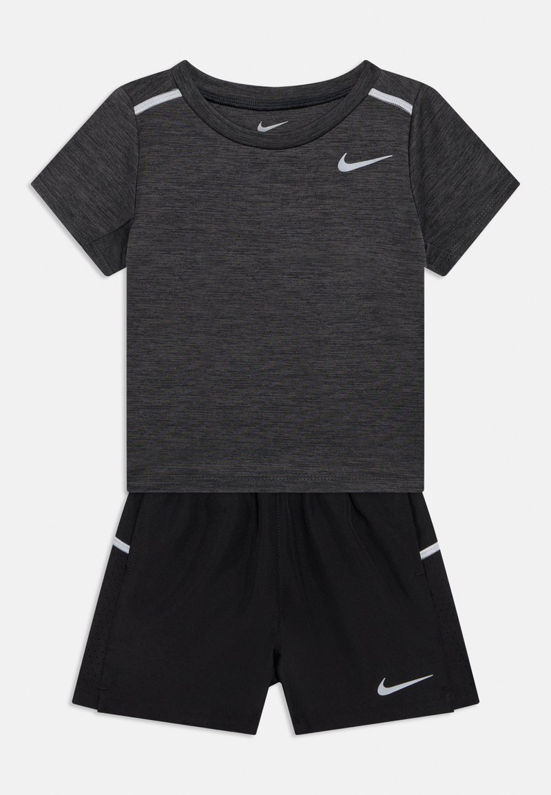 Ensemble sportif Nike comprenant un t-shirt gris à manches courtes et un short noir. Le haut présente un col rond ; les deux pièces comportent des accents réfléchissants.