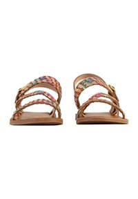 Sandalias planas trenzadas con suela de cuero marrón. Las correas tejidas multicolores tienen acentos florales. Diseño minimalista con punta y parte trasera abiertas.