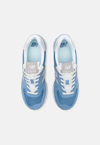 Ljust blå sneakers i mesh och mocka, med vita snören, en vadderad krage och en silverlogotyp. Utrustade med en gummisula och kontrasterande detaljer.