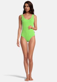 Maillot de bain une pièce néon vert lumineux avec une texture côtelée, doté de larges bretelles et d'un décolleté arrondi. Fini lisse et couverture minimale.