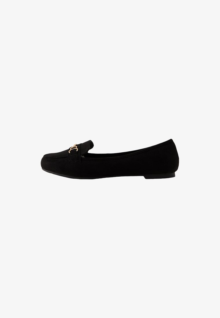 Le scarpe flat in suede nero presentano una punta arrotondata, una fascia decorativa con hardware dorato e un tacco basso. Texture liscia e design minimalista.