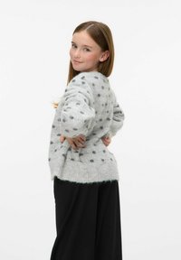 Grauer, gestrickter Pullover mit schwarzen Punkten, lockere Passform, gerippter Saum und langen Ärmeln, kombiniert mit schwarzen Hosen. Einfaches, strukturiertes Design.