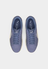 Ζευγάρι μπλε αθλητικά παπούτσια Puma softfoam με κορδόνια, σε άποψη από πάνω, σε λευκό φόντο.