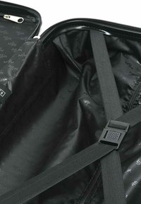 Interior de maleta negra con cremallera y acabado liso, que cuenta con correas elásticas y un forro con patrón de logo. El diseño es elegante y funcional.