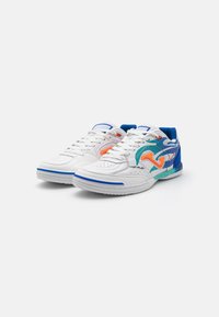 Zapatillas deportivas blancas con acentos en azul y turquesa. Las características incluyen lados perforados, un logo colorido y un tejido texturizado cerca del talón.