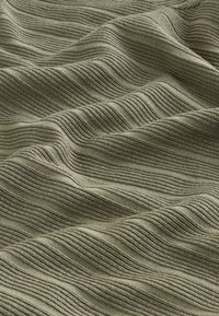 Material verde texturat cu dungi ondulate subtile, având grosimi variate. Suprafață netedă cu aspect moale și țesut.
