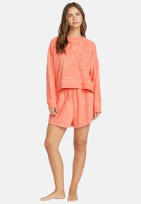 Set da loungewear in tessuto corallo con una maglia a maniche lunghe dalla vestibilità ampia e pantaloni corti abbinati, caratterizzato da un delicato motivo a palme e polsini a costine.