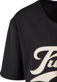 Tricou negru cu mânecă scurtă și gât în V, cu un material texturat și un design grafic crem contrastant pe față.