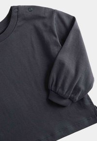 Dunkelgraues Langarmoberteil mit rundem Ausschnitt, weichem Baumwollstoff, Druckknopfakzenten an den Schultern und strukturierten gerippten Bündchen.