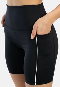 Zwarte sportshorts met een hoge taille, een gladde textuur, met een zijzak en een contrasterende witte ritsdetail.