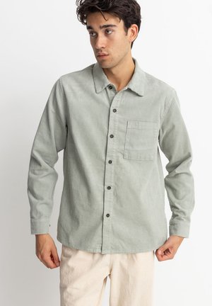 Light green corduroy shirt with long sleeves, button front, one chest pocket, and a fold-down collar. Features ribbed texture and brown buttons.
