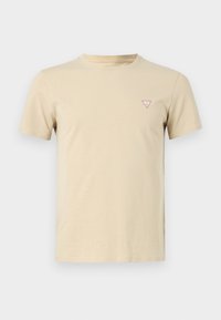 T-shirt beige à manches courtes avec un petit logo triangle rouge et blanc sur la poitrine gauche, présenté sur un fond blanc uni.