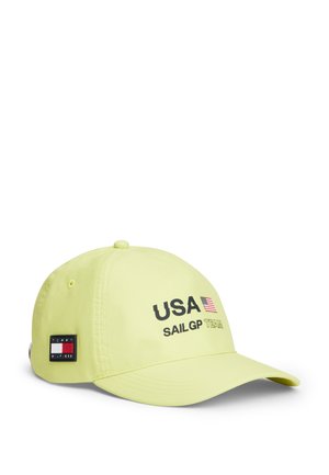 Jasnożółta czapka baseballowa z napisem "USA SAILGP TEAM" i amerykańską flagą na przodzie, z naszywką z logo Tommy Hilfiger po boku.