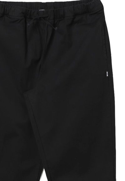 Pantaloni neri con vita elasticizzata e cordino, tessuto liscio e tasche laterali. Taglio semplice con minimalismo nei dettagli.