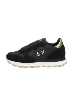 Zapatillas deportivas negras con una textura suave y de ante, suela blanca, detalles en dorado y logo en el lateral. Vista lateral.