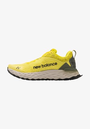 Zapatilla de correr New Balance en malla amarilla neón, con una suela gruesa y texturizada con acentos negros y un talón reforzado para mayor soporte.
