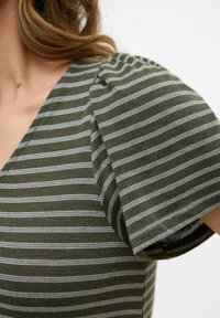 Top de rayas verde oliva con líneas blancas, con un escote en V profundo y mangas abullonadas. Tejido de mezcla de algodón, textura suave y ajuste casual.