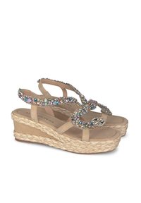 Sandali platform beige con suola in espadrille intrecciata, adornati con strass multicolori disposti in un design ondulato sulle cinghie.