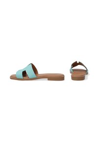 Turquoise flat slide sandals with a textured upper, featuring a cross-strap design and a brown rubber sole. Simple and open-toed design.