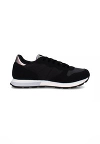 Sneaker nera caratterizzata da un mix di materiali scamosciati e sintetici, con una suola intermedia bianca, punta tonda e un accento metallico sul tallone.