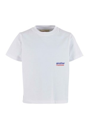 T-shirt en coton blanc à manches courtes et col rond. Présente un petit logo bleu et rouge sur la partie gauche de la poitrine. Texture lisse.