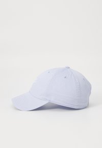 Svetlofialová baseballová čiapka vyrobená z bavlny s zakriveným šiltom, s vyšitým logom na prednej strane a ventilačnými otvormi na vrchnej časti.