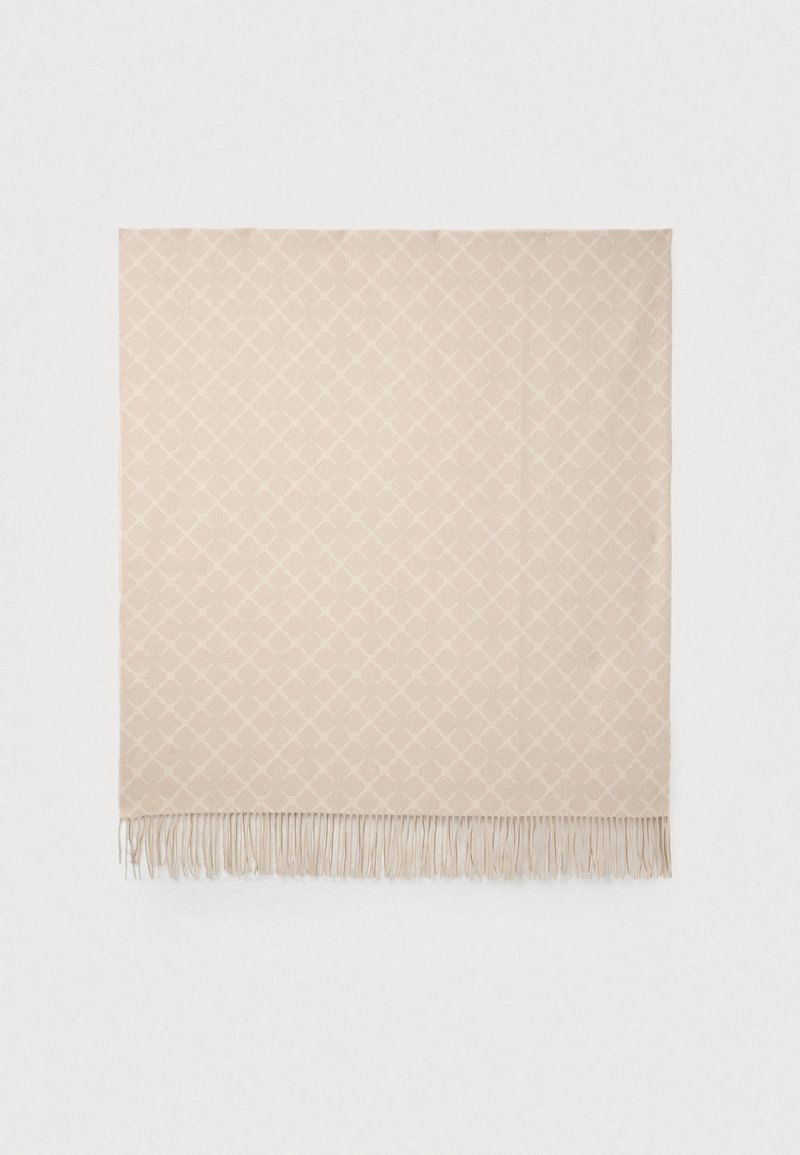Μπεζ υφαντή κουβέρτα με διαμάντι μοτίβο, φινιρισμένη με λεπτές φουντίτσες στις άκρες. Μαλακή υφή και ορθογώνιο σχήμα.