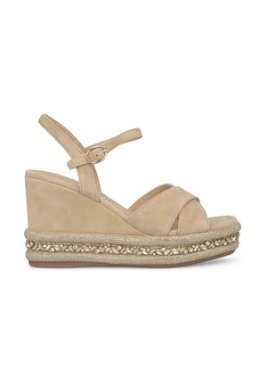 Beige suede wedge sandals with crossed straps and an adjustable ankle strap, featuring a textured gold and clear stone embellishment.