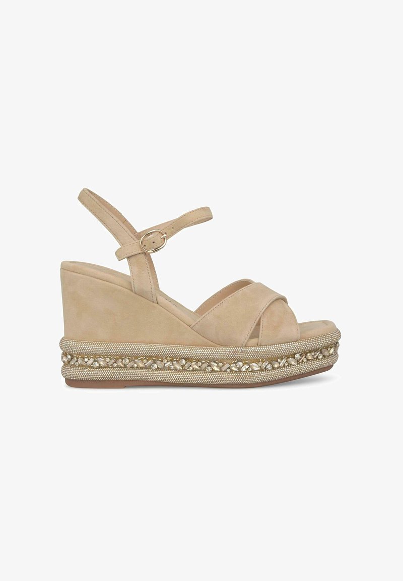 Sandali wedge in suede beige con cinturini incrociati e una cinghia alla caviglia regolabile, dotati di un sottile abbellimento in oro testurizzato e pietre trasparenti.
