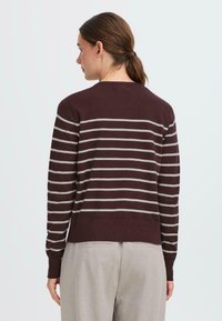 Maroon striped sweater featuring thin gray horizontal stripes, ribbed cuffs, and a crew neckline, worn with light gray trousers.