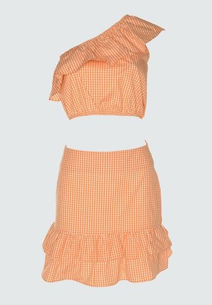 Orange og hvid ternet to-delt sæt med en skulder, flæset croptop og matchende flæset mininederdel.