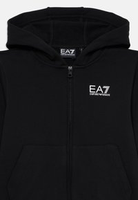 Schwarzer Reißverschluss-Hoodie aus weichem Material, mit einer Vordertasche, Kordelzugkapuze und weißem EA7-Logo auf der Brust.