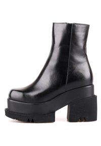 Stivale ankle in pelle nera con finitura lucida, suola a piattaforma chunky e tacco a blocco. Presenta una silhouette elegante e sfilata.