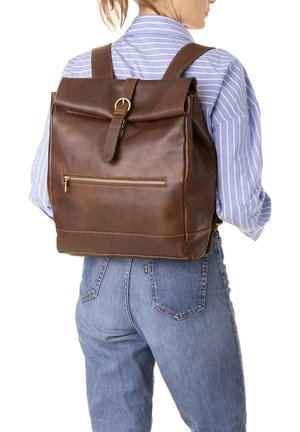 Brown leather backpack with rolled top, gold hardware, and an exterior zip pocket. Features a clean design and structured shape.
