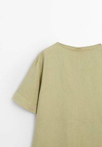 Haut à manches courtes, vert olive, fabriqué dans un tissu léger. Doté d'un col rond et de détails de coutures visibles au dos.