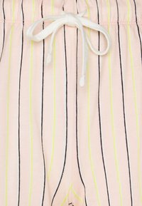 Lichtroze shorts met verticale zwarte en neongele strepen. Elastische tailleband met een witte trekkoord. Zachte, lichte stof.