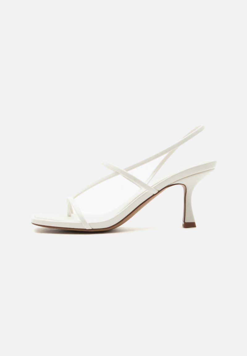 Sandale blanche à talon pour femme avec lanières fines croisées et bride arrière sur fond clair.