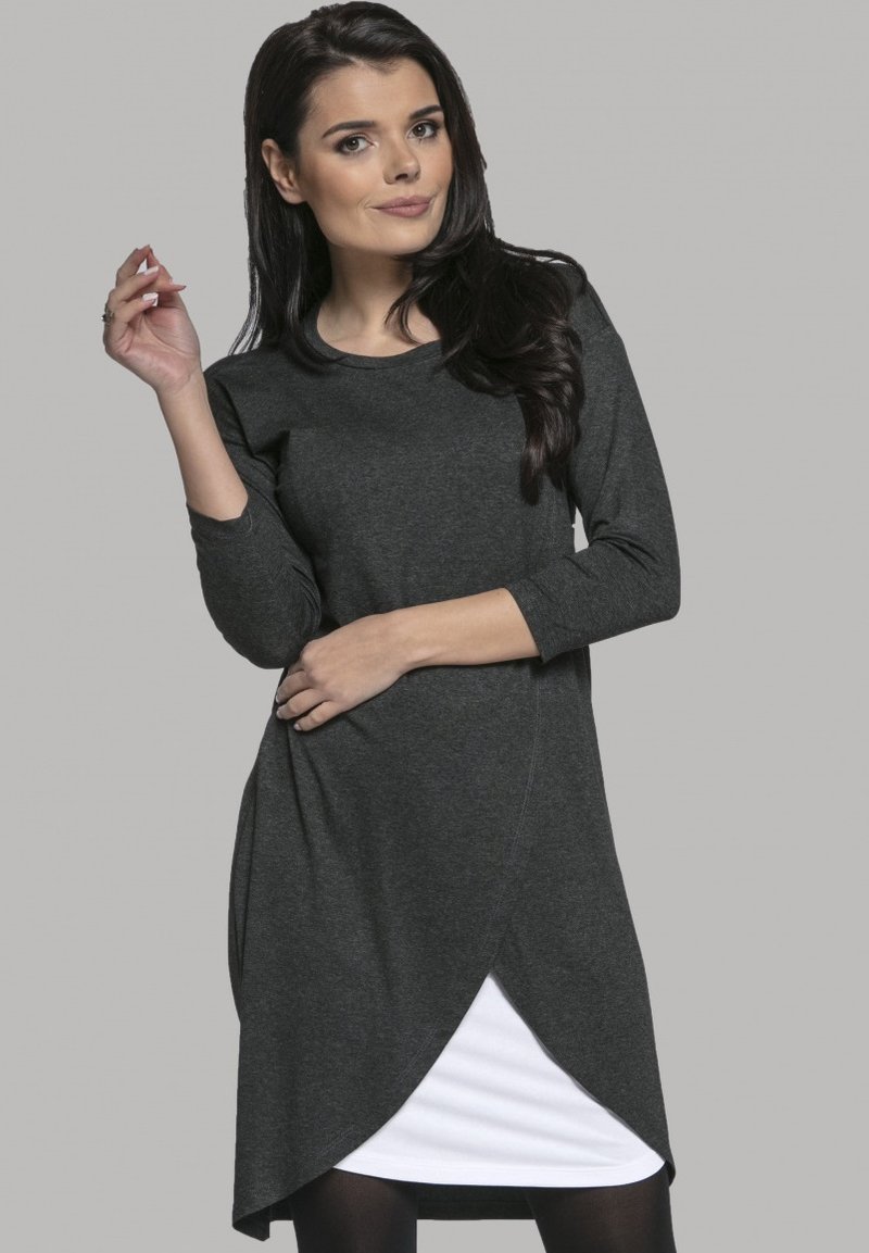 Dunkelgraues Langarmkleid mit Rundhalsausschnitt und asymmetrischem Saum, über einem weißen Unterkleid geschichtet. Weicher Stofftextur.
