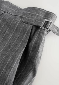 Pantalons en lin gris avec un motif à rayures, dotés d'une taille large, d'un détail de boucle et de pinces pour plus de texture et de design.