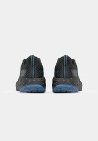 Baskets de course noires avec un dessus texturé, des accents bleus, un talon renforcé et une semelle extérieure tachetée, conçues pour accroître la traction et le confort.